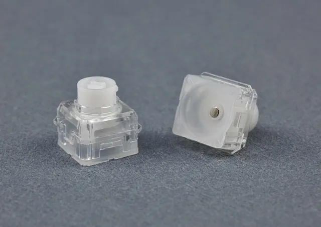 AEBoards Raeds HE RGB Switch, zwei transparente Switches mit weißem Stem, Oberseite und Unterseite mit Magnet