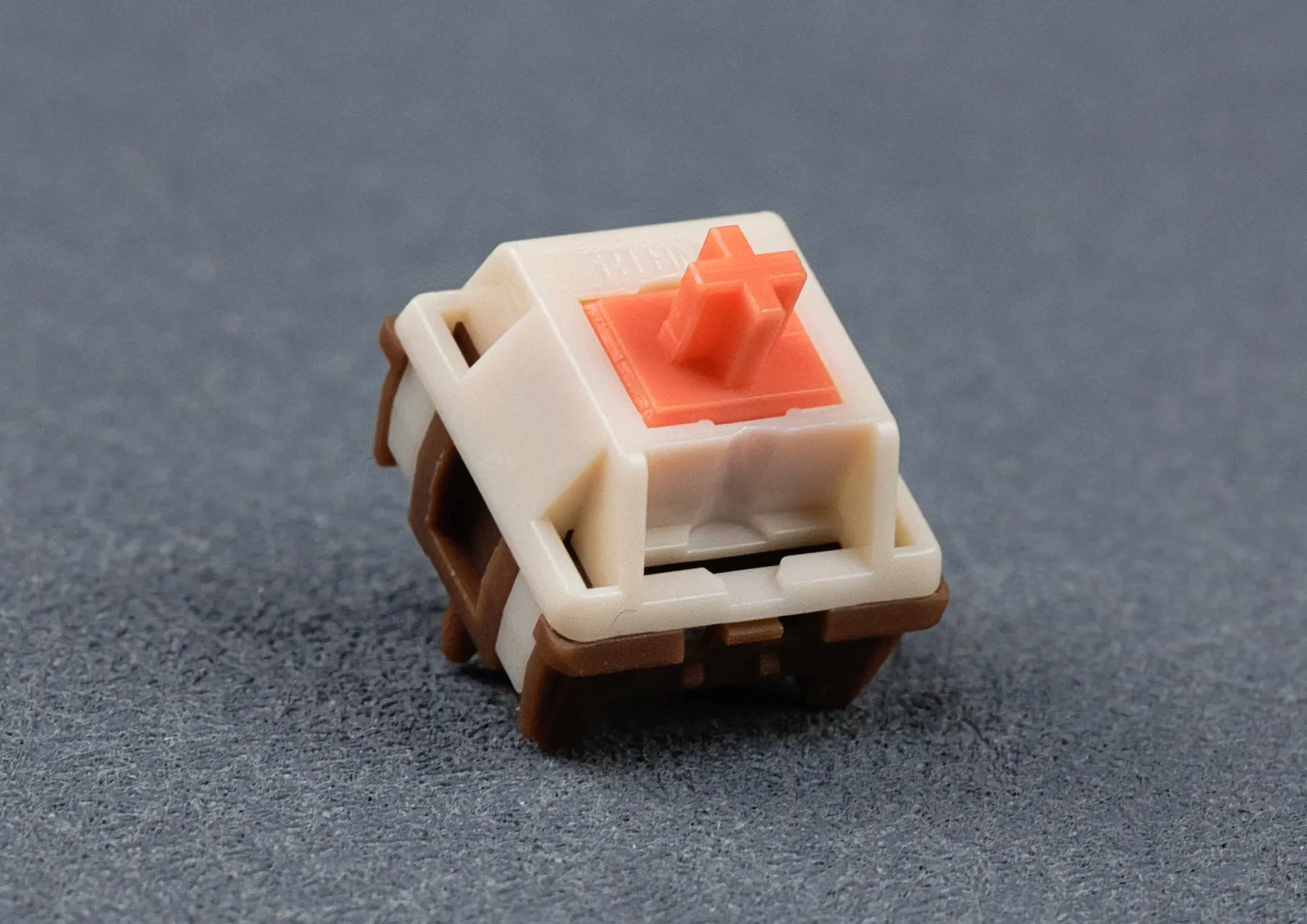 HMX Saru V2 Switch, cremefarbenes Top Housing, dunkelbraunes Bottom Housing, korallroter Stem, Schrägansicht