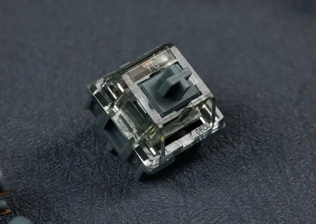 HMX SongYue Switch, rauchgraues transparentes Top Housing, graues Bottom Housing und Stem, Schrägansicht