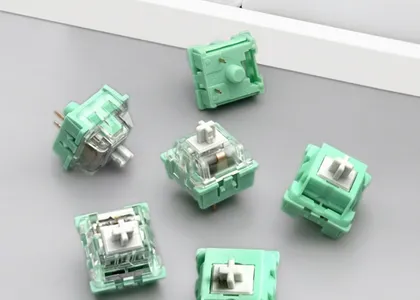 Green mechanical keyboard switches on a gray surface with a white background