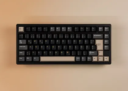 Rainy75 in Schwarz, ISO-DE mit dunklen und beigen Keycaps, Draufsicht auf beigem Hintergrund