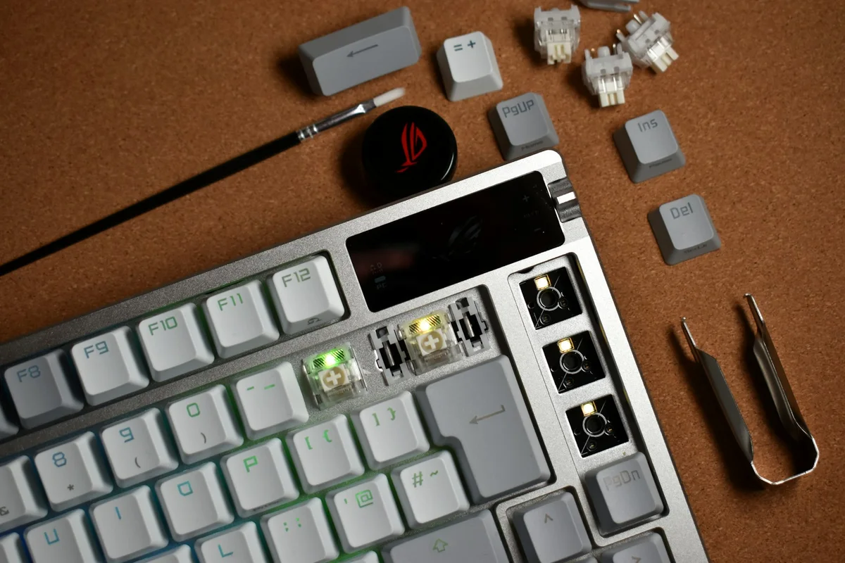 Mechanical keyboard with removed keycaps, loose switches, and the tools needed to change its parts