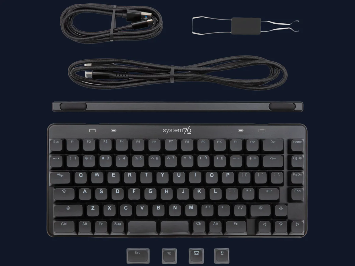 Custom keyboard, USB cables, puller, and spare keycaps arranged before assembly