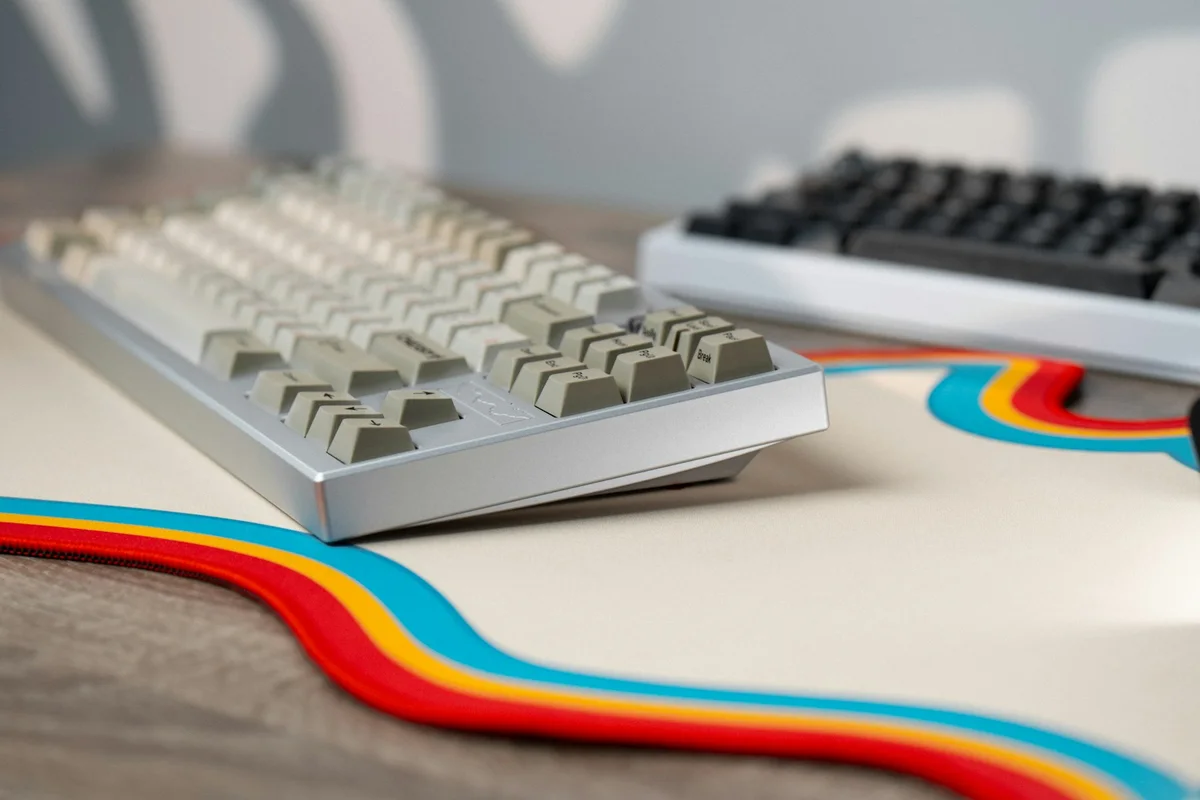Two mechanical keyboards with different layouts and case styles on the same desk