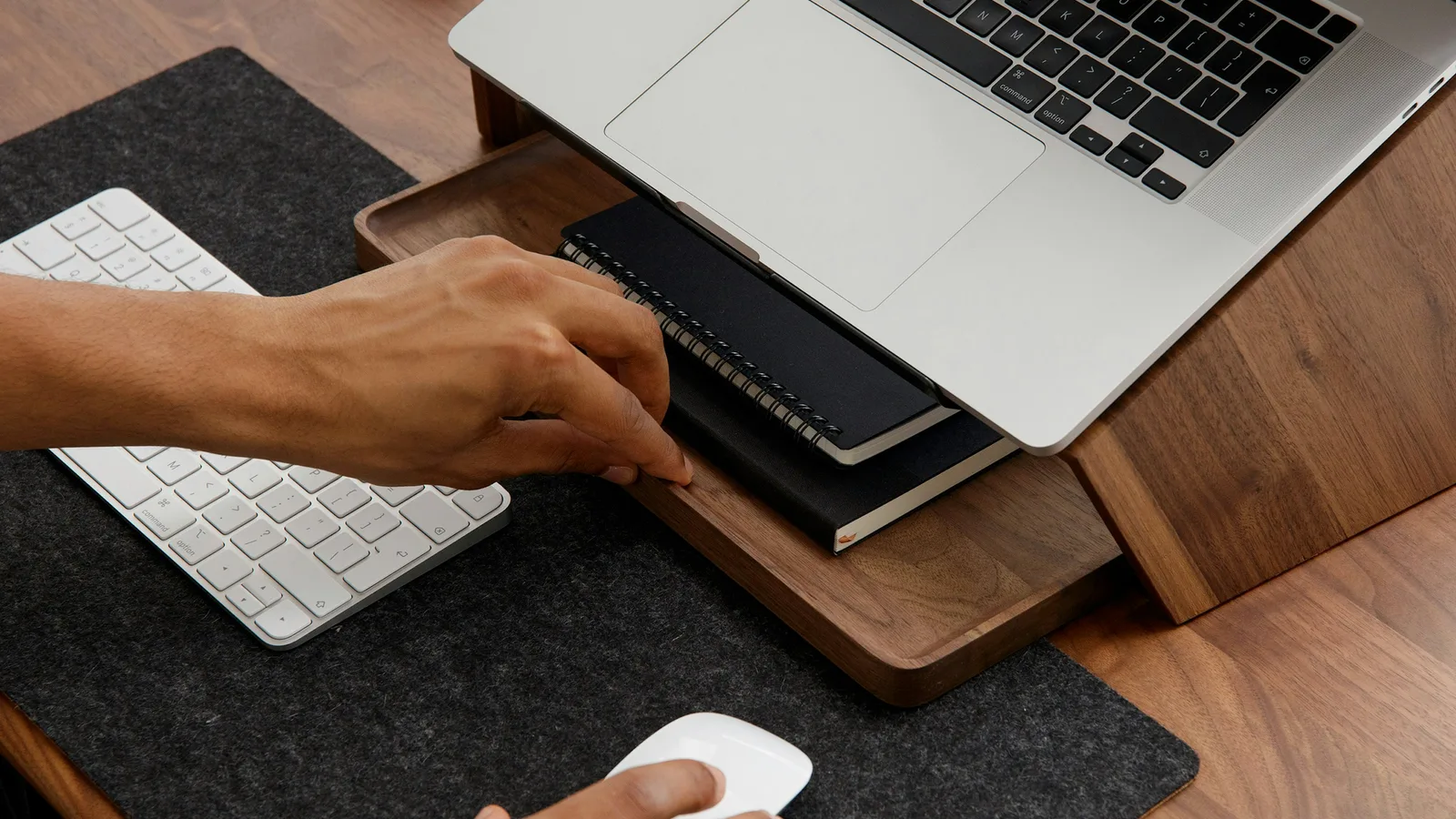 Person using an external keyboard and mouse at an ergonomic desk setup