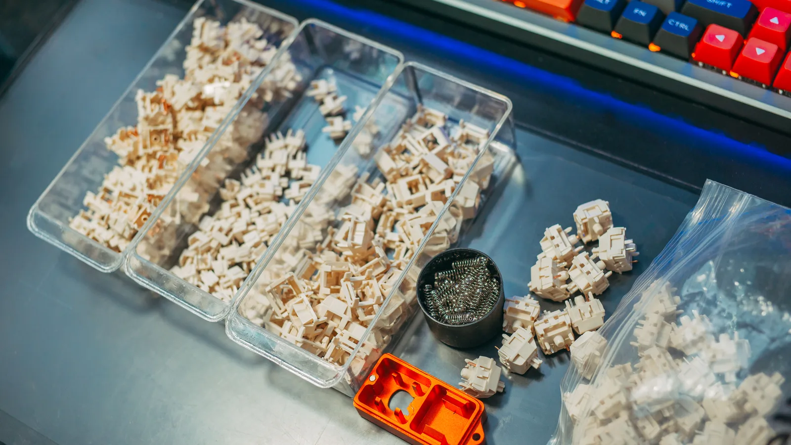 Mechanical keyboard switches, springs, tools, and a finished keyboard arranged for modding