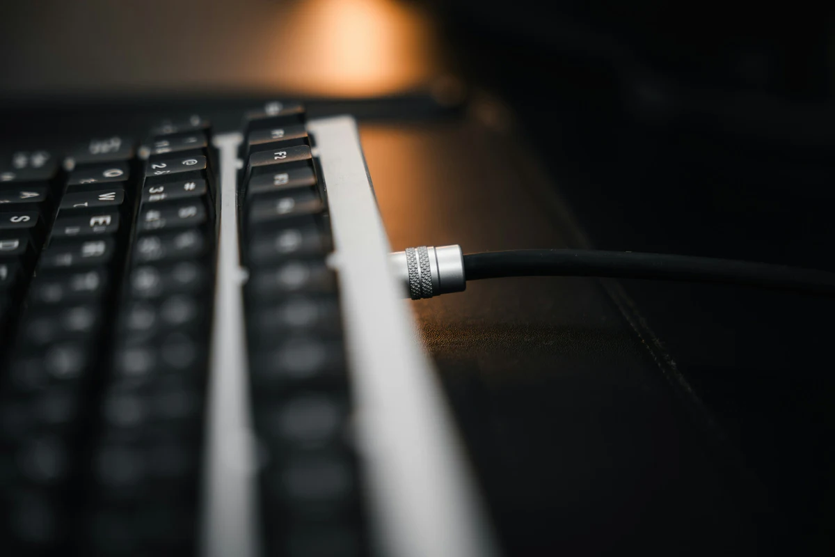 Close-up of a data cable plugged directly into a keyboard for connection troubleshooting