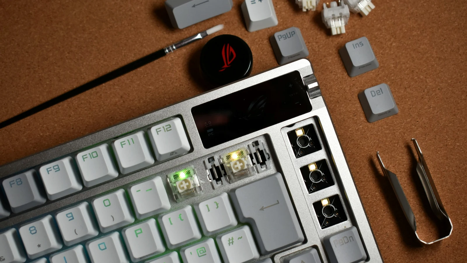 Partially disassembled mechanical keyboard surrounded by switches and repair tools