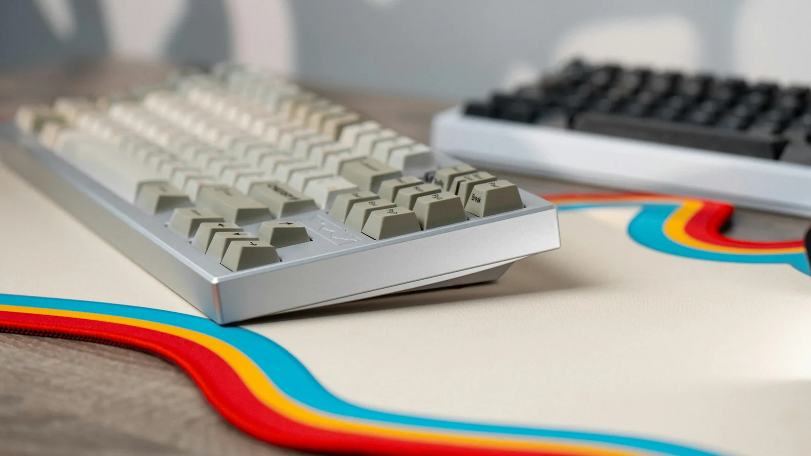 Two mechanical keyboards of different sizes placed together on a desk
