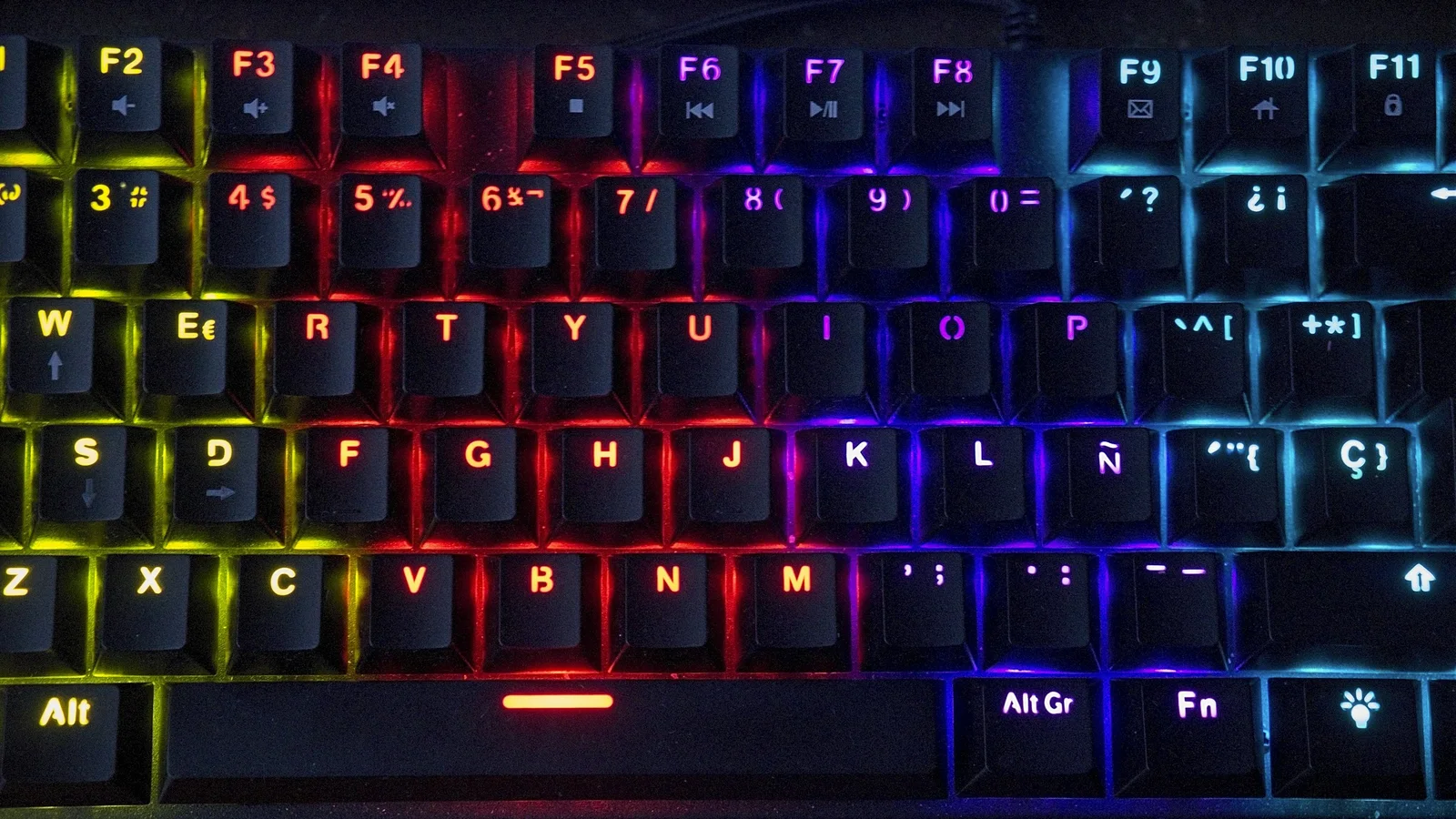 Close-up of a mechanical keyboard illuminated with rainbow RGB lighting